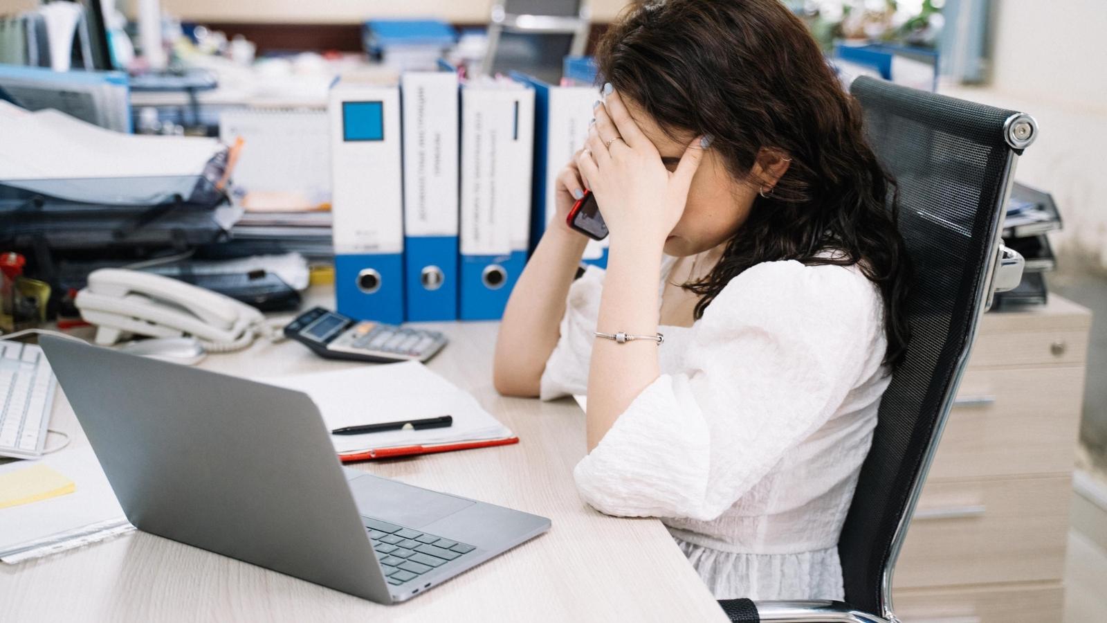 She spent 8 months drowning without onboarding, docs, or clear goals—then they handed her a fresh hire to get up to speed by Monday. overworked woman at her cubicle