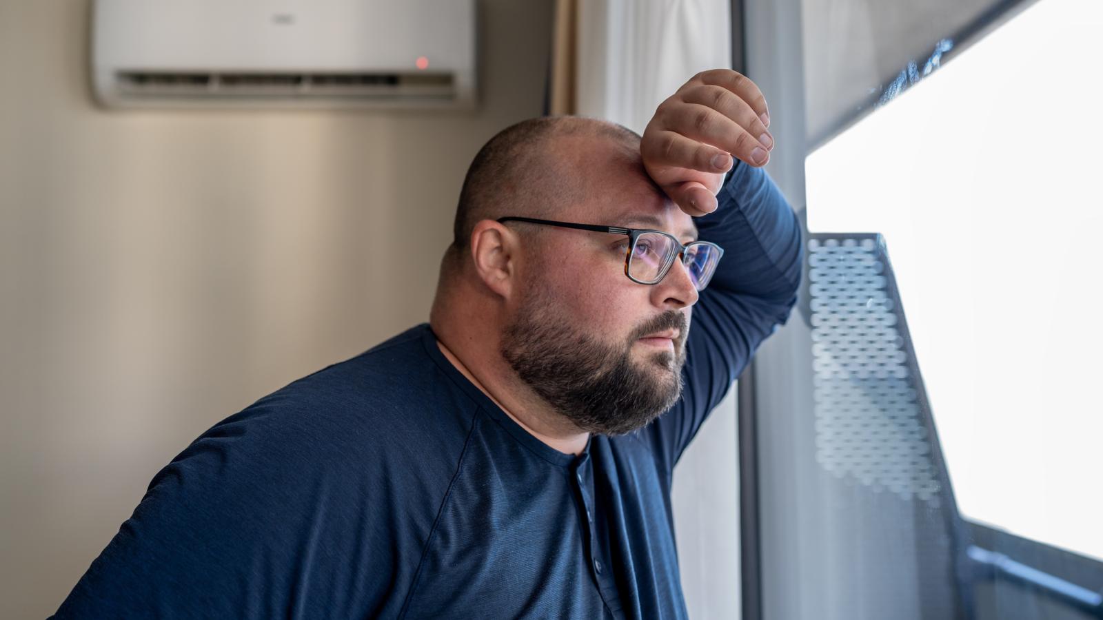 His Neighbors Have a Camera Pointed Right at His Front Door — Recording Every Time He Comes and Goes man looking out his window