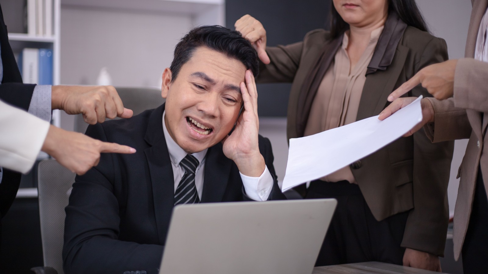 work colleagues berating a man