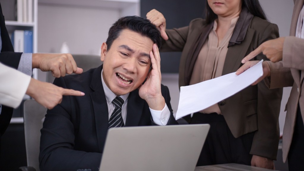 work colleagues berating a man