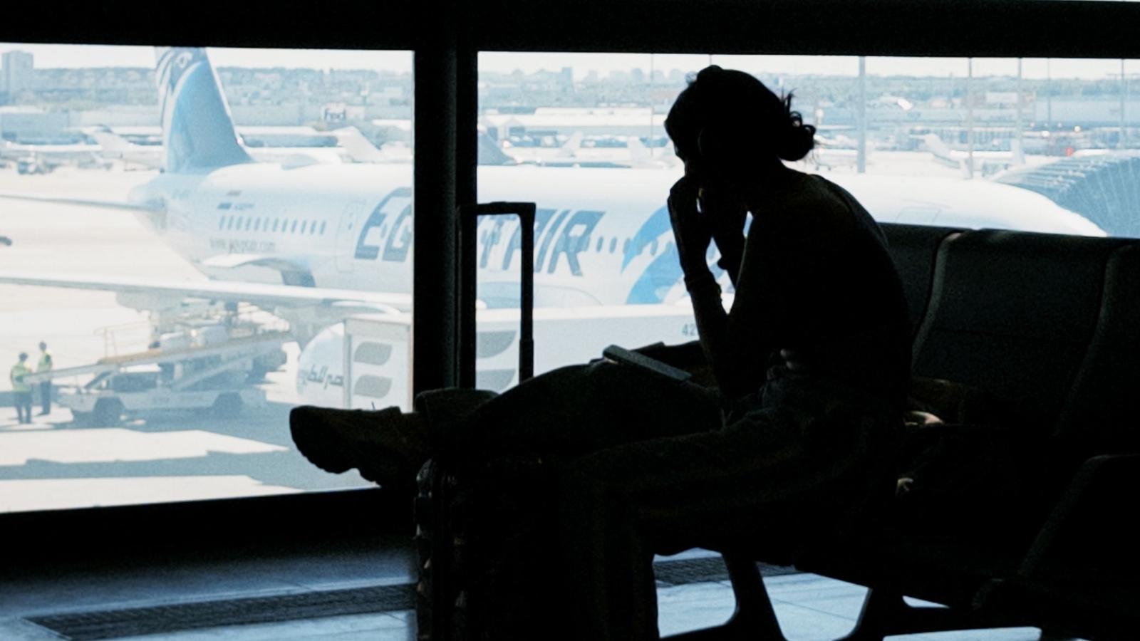 silhouette of woman sitting in airport