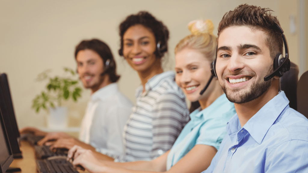 Their Department Was Reassigned to Tier 3 Technical Support Over Night—Then Their Manager Denied All Training and Demanded SLA Compliance smiling employees in a call center wearing headsets