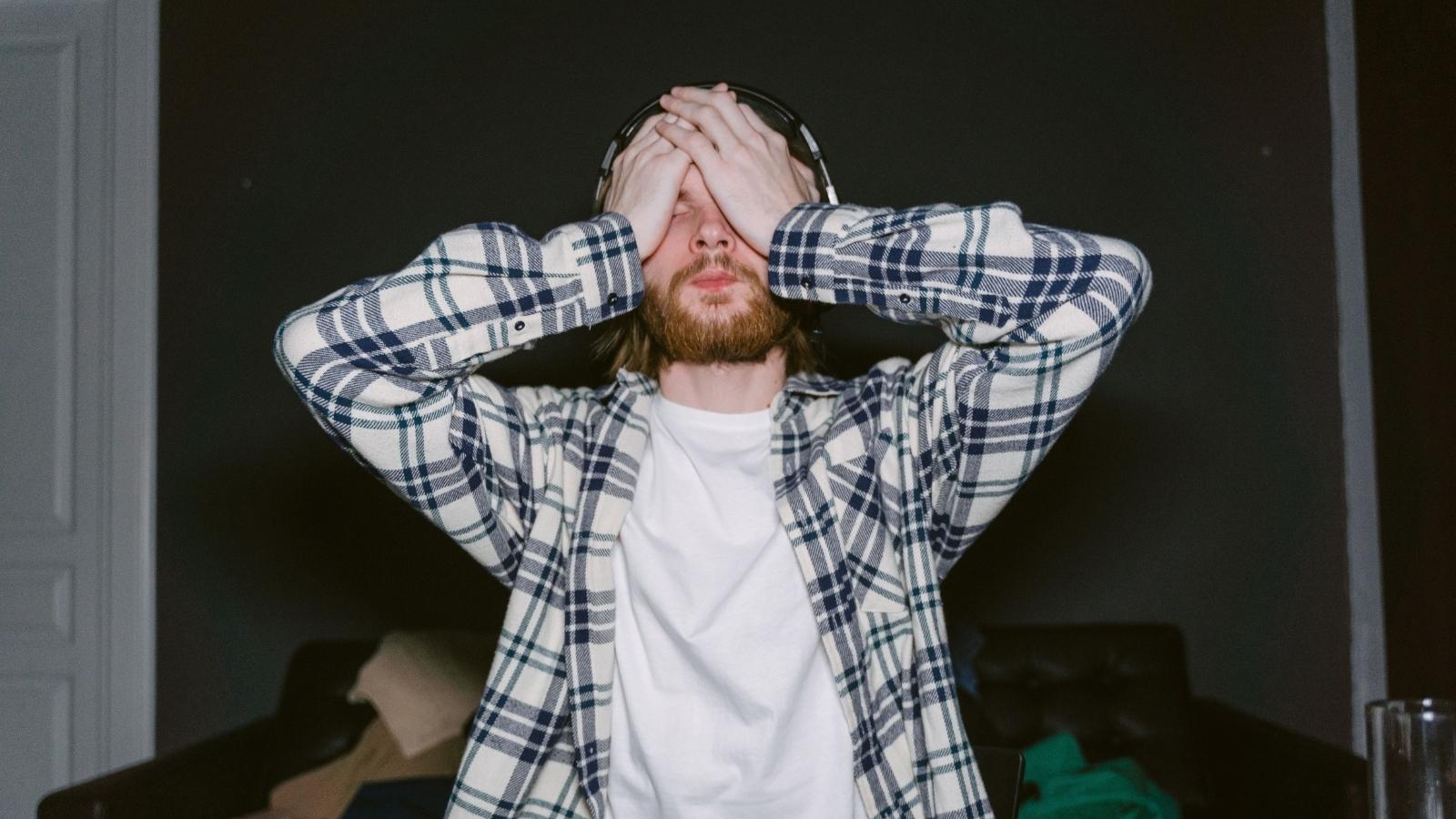 He Gave Her Months of Notice He Was Done Babysitting. She Guilt Tripped Him Anyway stressed young man in a flannel shirt