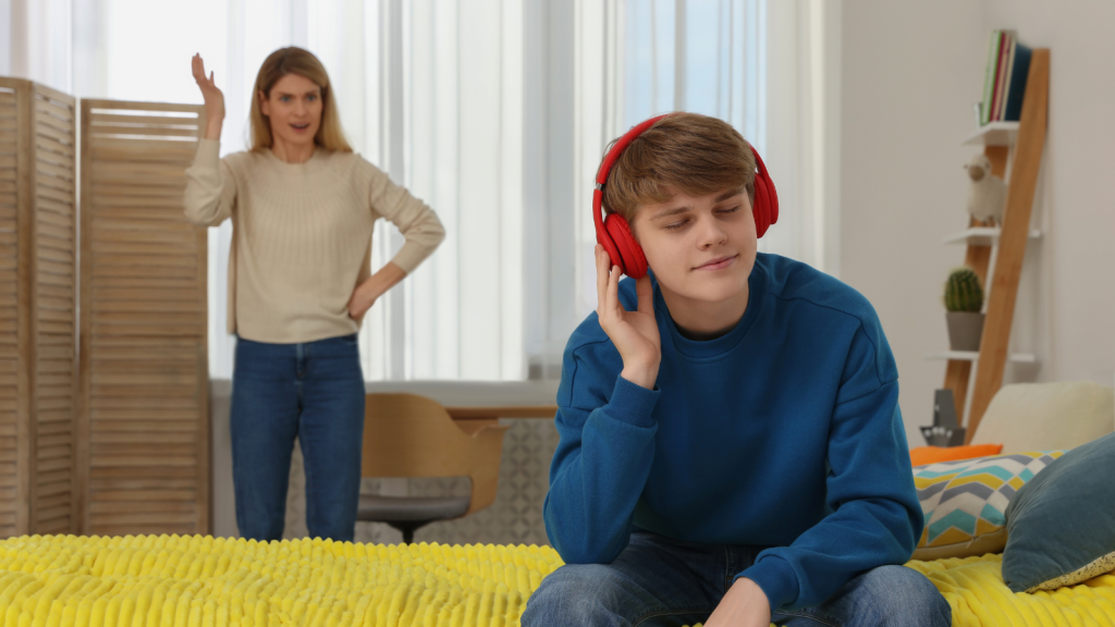 teenage boy wearing headphones trying to ignore his stepmom
