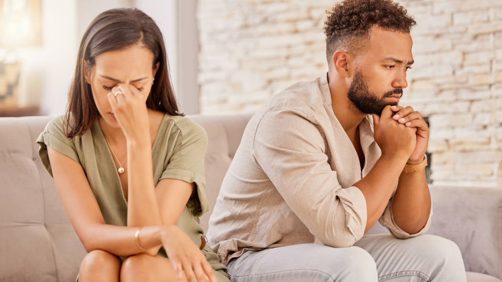 upset couple sitting on couch