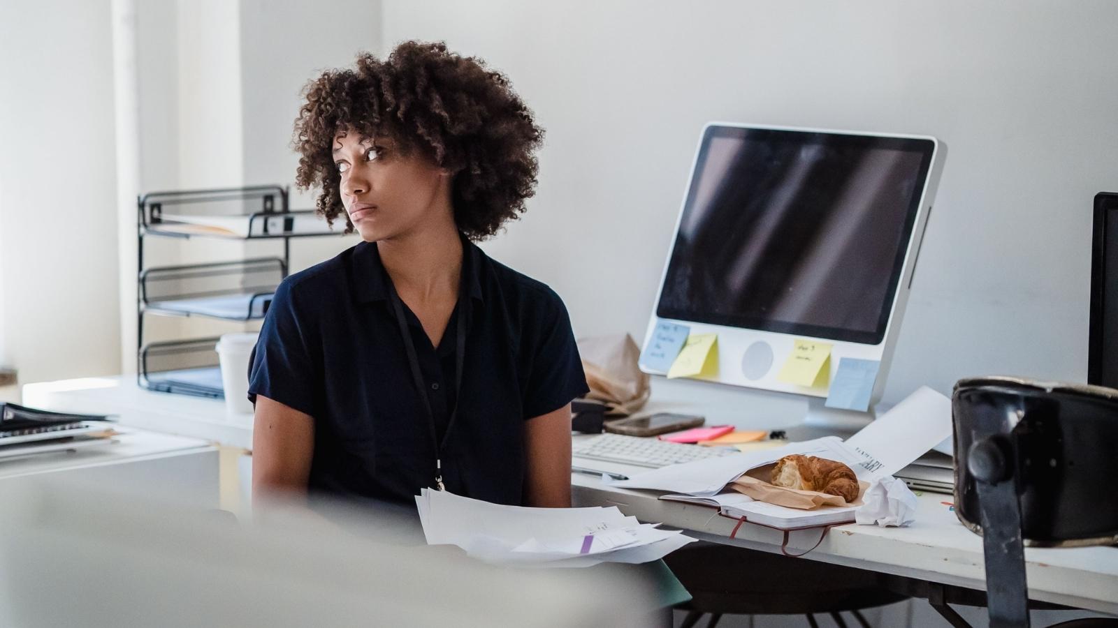 upset employee looking out the window in her office