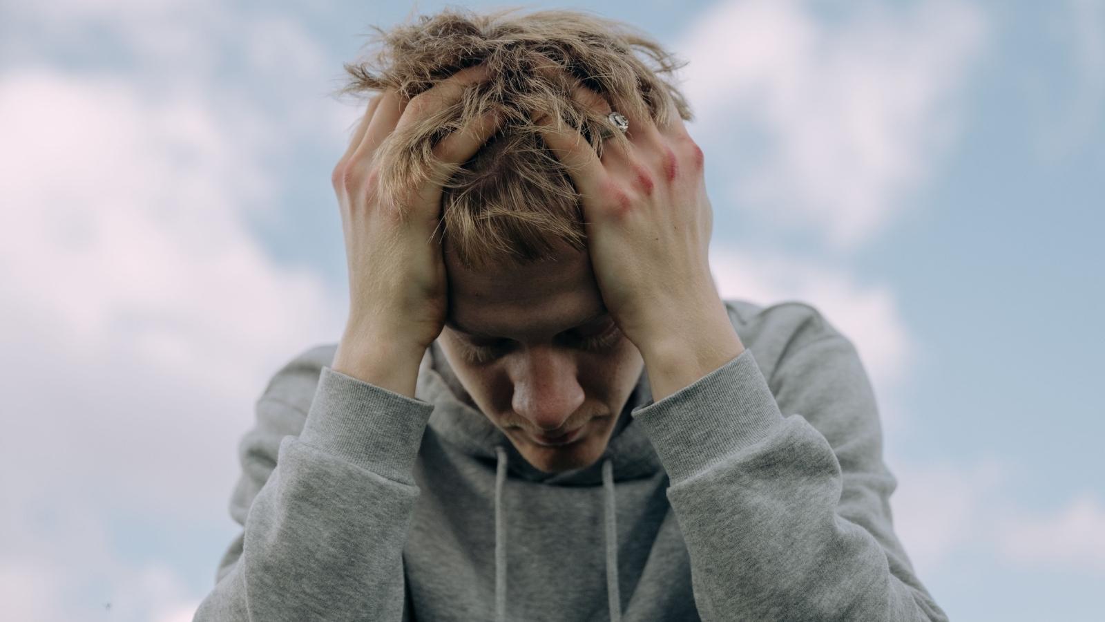 His Own Friends Kicked And Smashed His Cap — Then Told Him He Was Overreacting About It upset teenage boy putting head in hands
