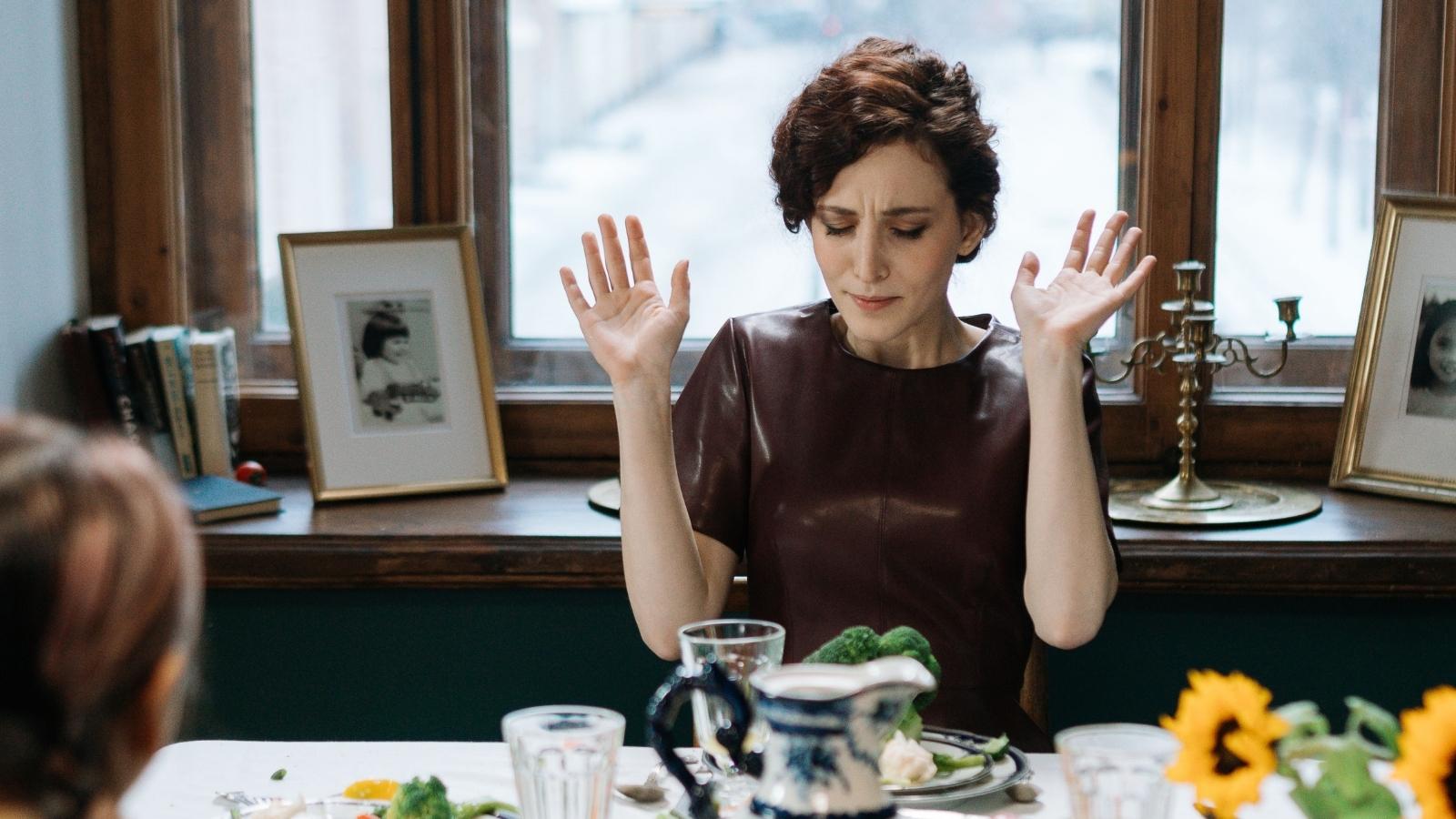 She Asked Her Friend to Stop Bragging About Her Salary at Dinner — Her Friend Accused Her of Being Jealous Instead woman appearing distressed at the dinner table