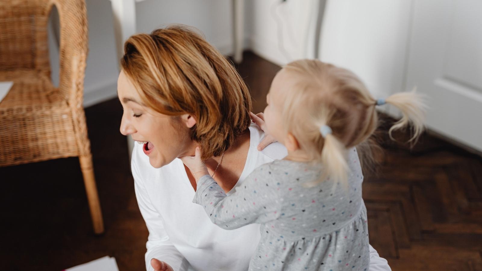 Shes Already Overwhelmed Caring for Her Own Kids — But Still Feels Pressured to Babysit Her Siblings Too woman babysitting a toddler