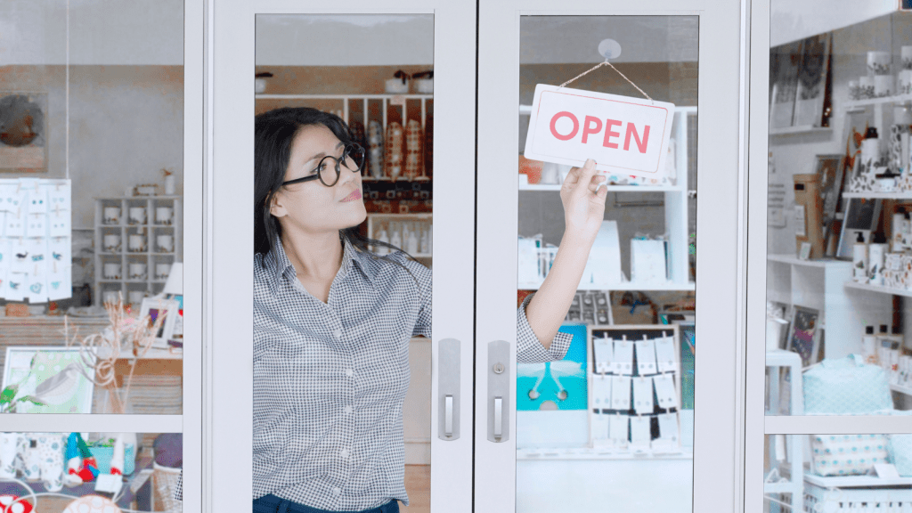 woman business owner flipping open sign
