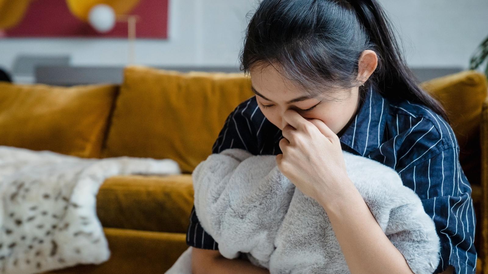 She Changed Her Name — Her Sister Refuses to Stop Using the Old One Around Her Kids woman crying on her couch