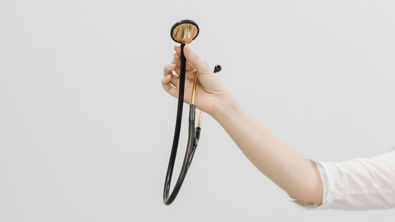 She Gave Her Preteen Sister a Real Doctor Kit Made From Her Own Medical Gear — Their Mom Accused Her of Cheaping Out woman holding out a stethoscope