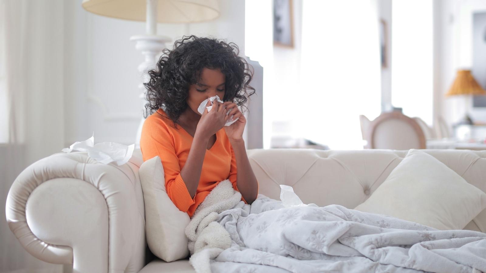 woman in orange shirt sick on the couch
