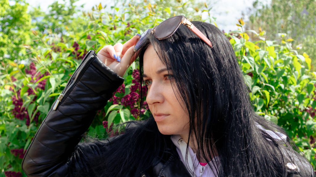 woman raising sunglasses outside