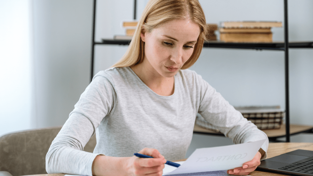 woman reading contract while sitting down