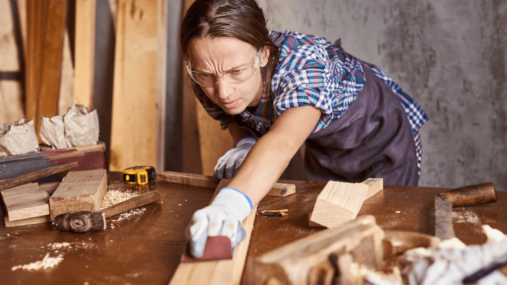 woman sanding a piece of wood