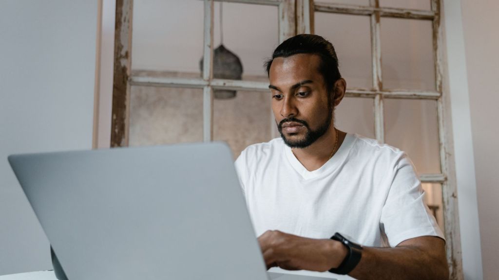 Man in white shirt working on his laptop
