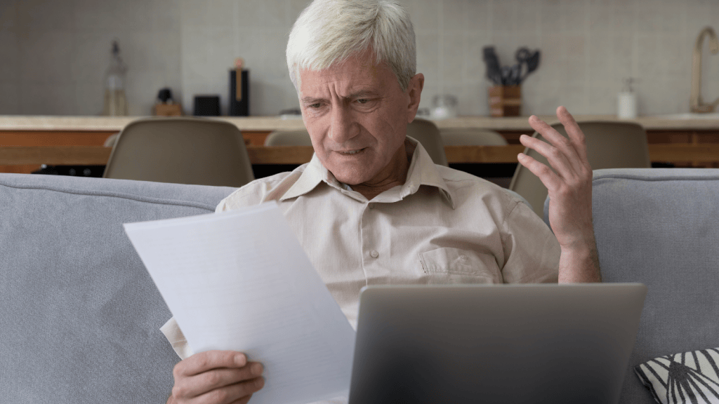 Older man frowning while reading paper