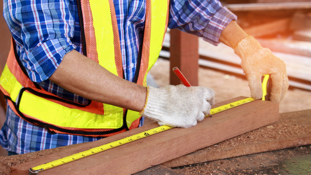 Person measuring wood with a tape measure