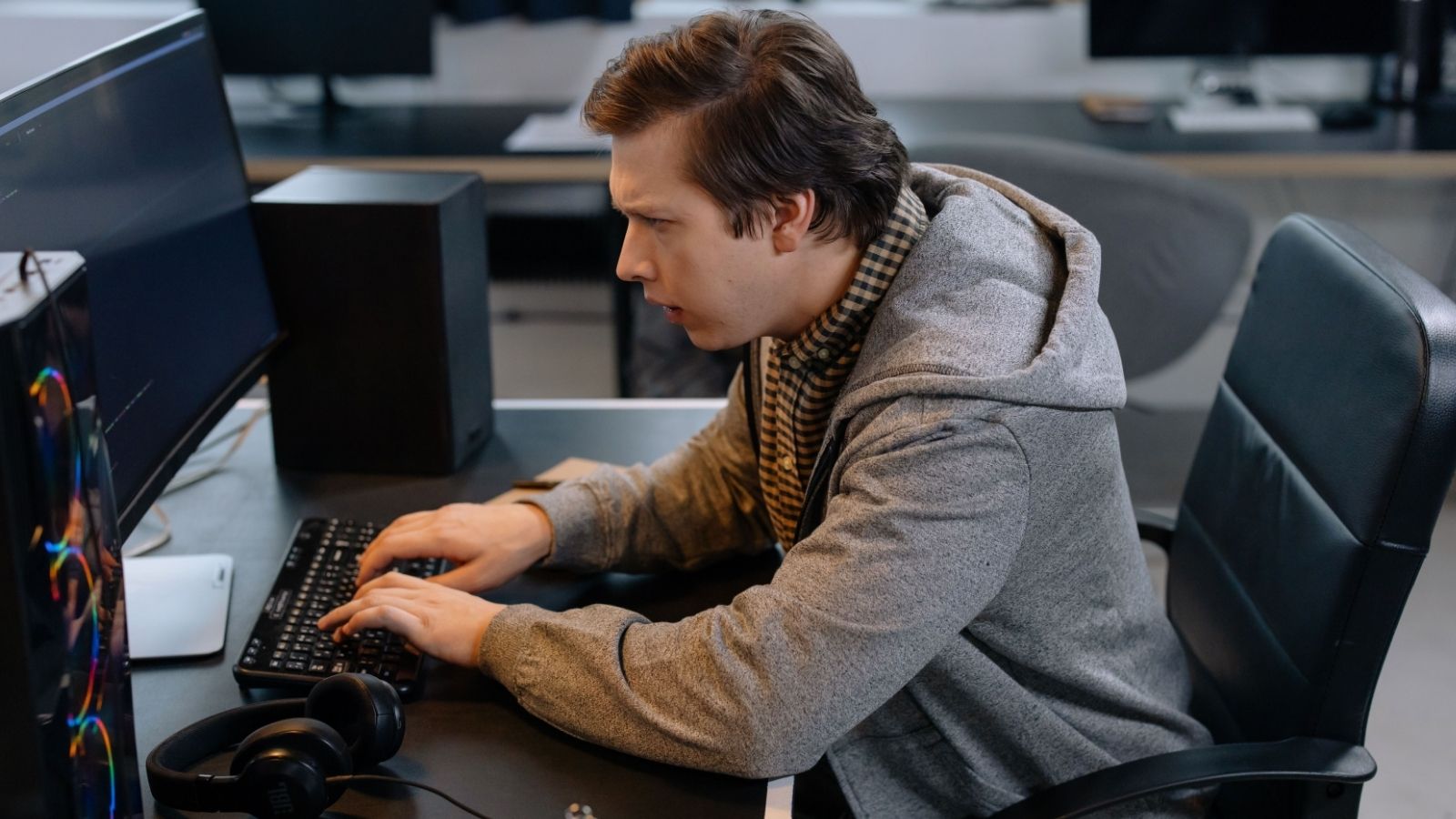 Man types, looking angry at his screen