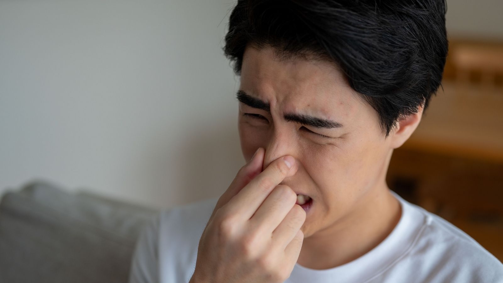 He Rented In A No Smoking Building — His Next Door Neighbor Wont Stop Smoking Anyway man covering his nose because of a bad smell