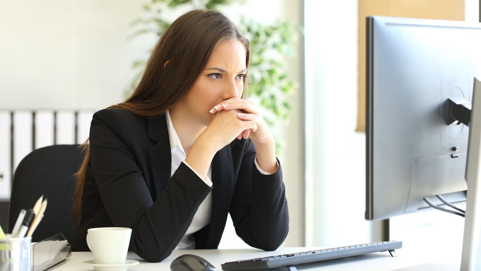 She Vented About Her Chatty Coworker to a Friend—Only to Get Called Into HR for Creating a Hostile Work Environment frustrated businesswoman staring at her computer monitor