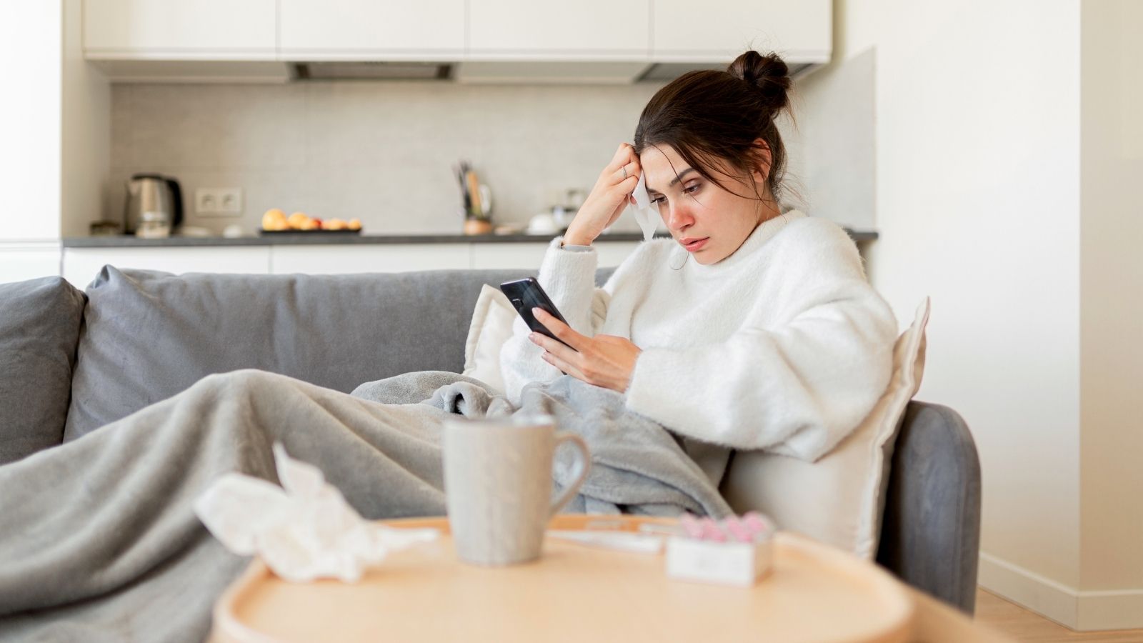 She Called In Sick, But Her Supervisors Boss Called Her Personal Phone To Remind Her She Was Still On Call sick woman at home looking at her phone