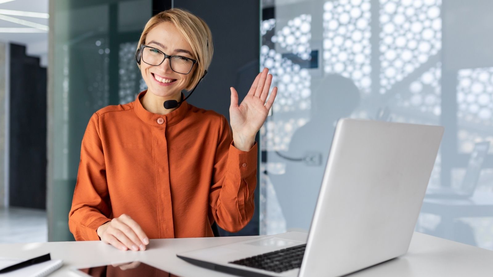 smiling and waving female tech support worker