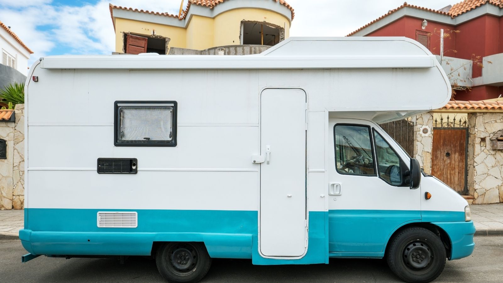 small motorhome parked in front of a house