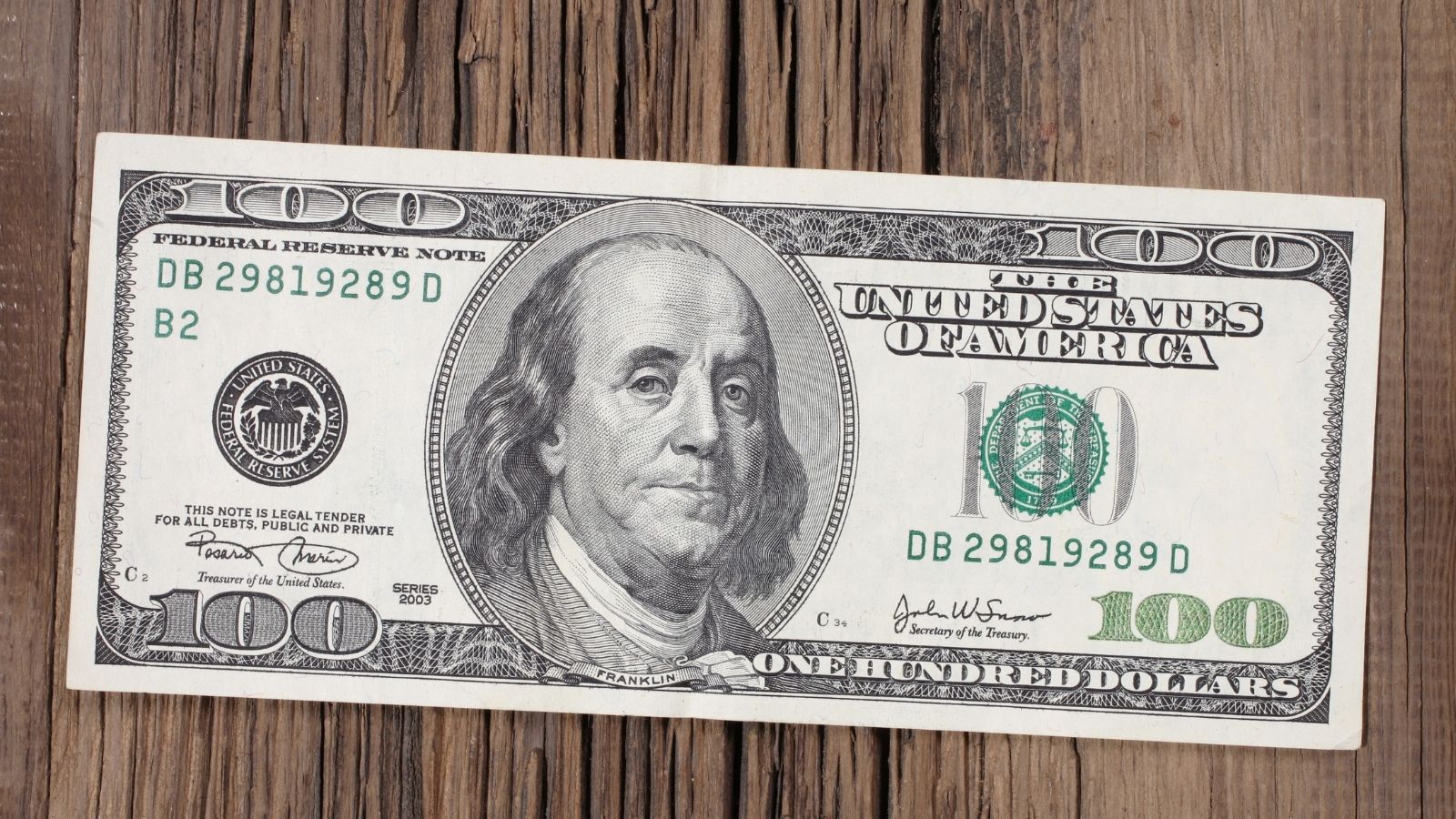 An Employee Stopped A Customer From Keeping A Bill She Thought Was Fake, Then Called The Cops, Only For It To Be Legit 100 dollar bill on a wooden table