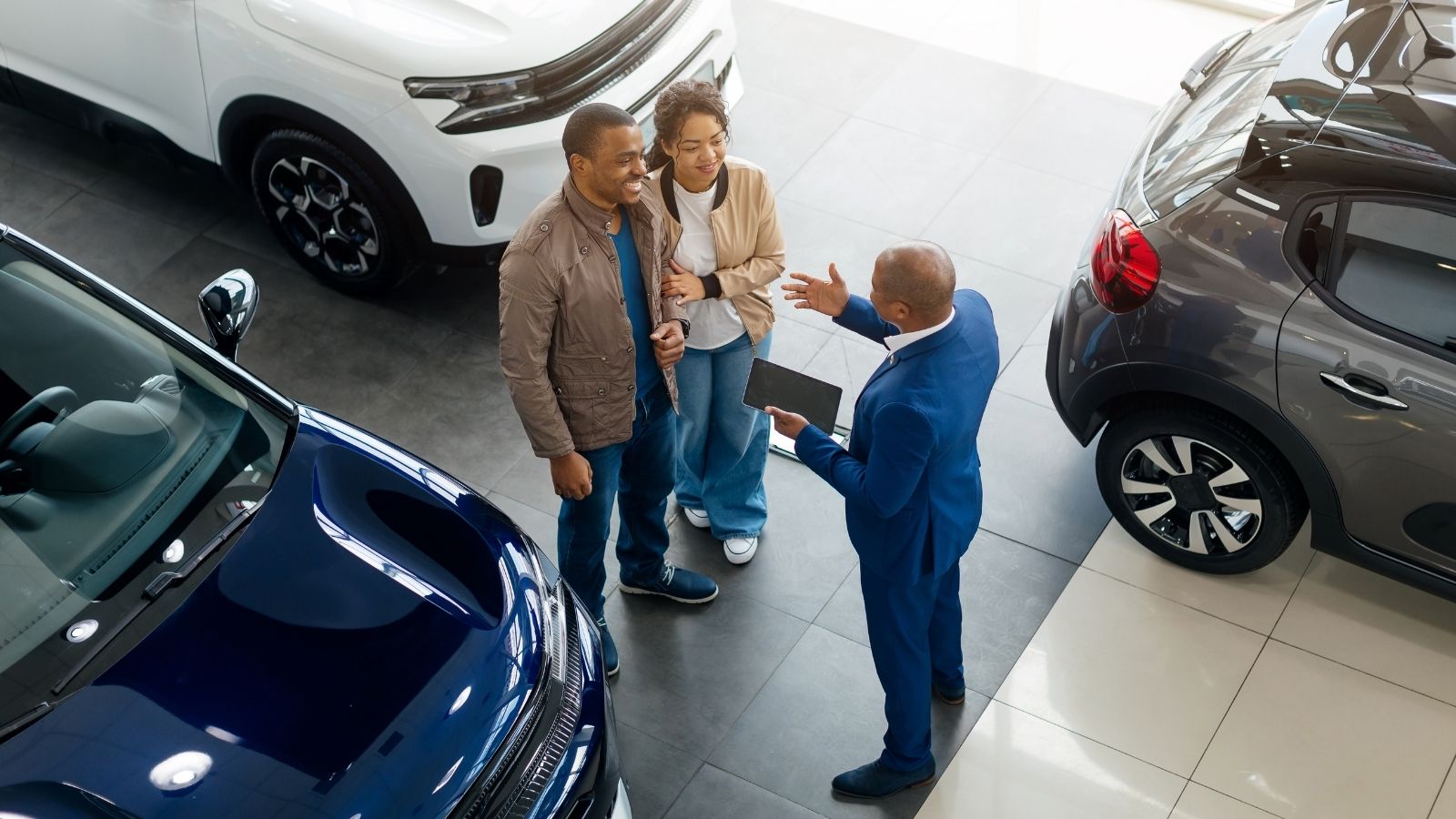 couple talking to a salesman at a car dealership