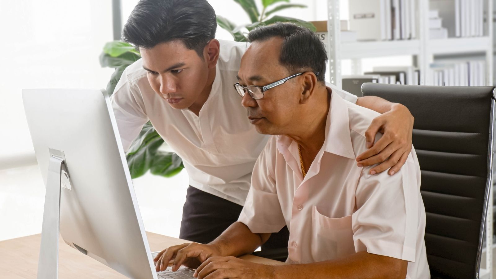 young man helping dad with computer