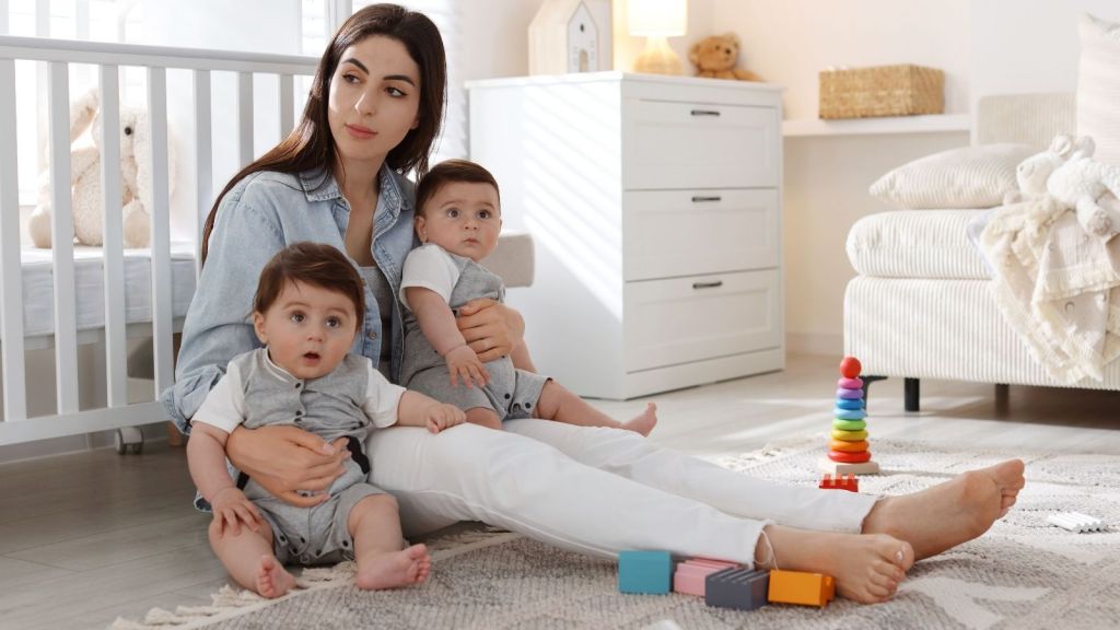 mom sitting on the floor with a baby and toddler