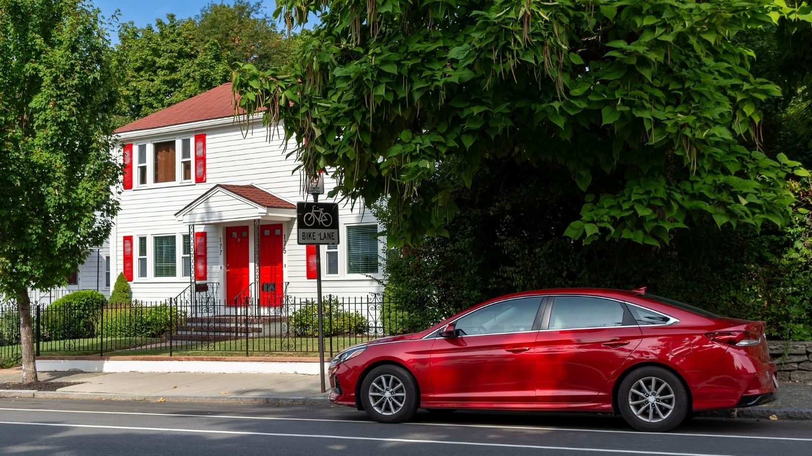 red car parked on a residential street