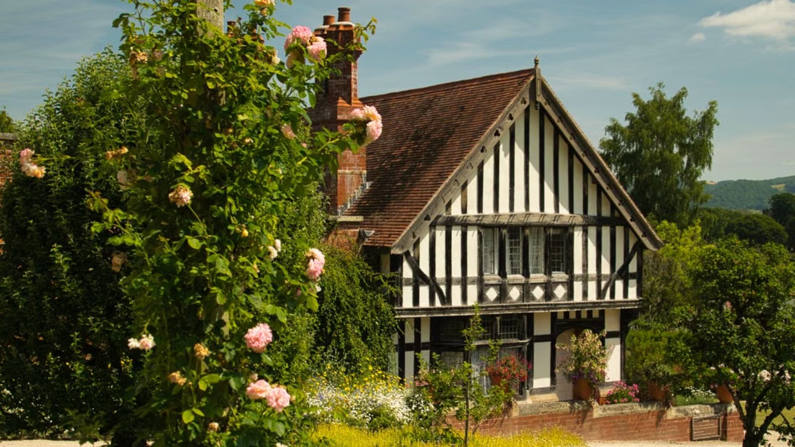 He Mentioned Spending Weekends at His Cottage—Until His Coworkers Turned His Second Home Into a Work Warfare Weapon A picturesque Tudor-style cottage surrounded by vibrant spring flowers and lush greenery