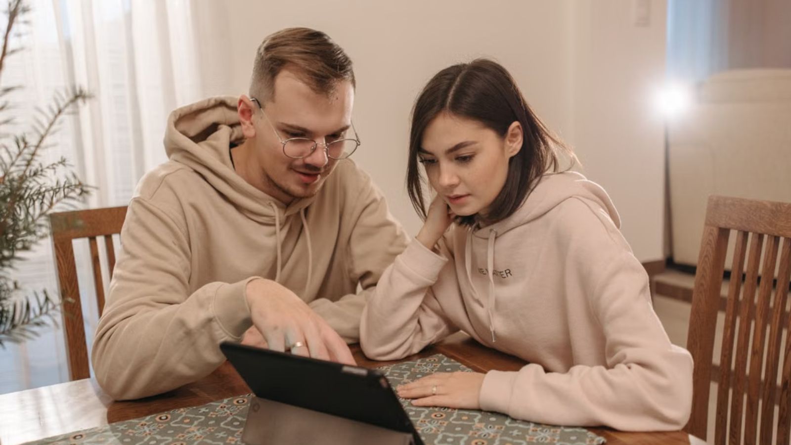 Man Tried Sharing Nostalgic Shows And Videos With His Girlfriend, But She Turned Each One Into A Lecture About Morality Man and woman in matching sweaters watching video on a tablet
