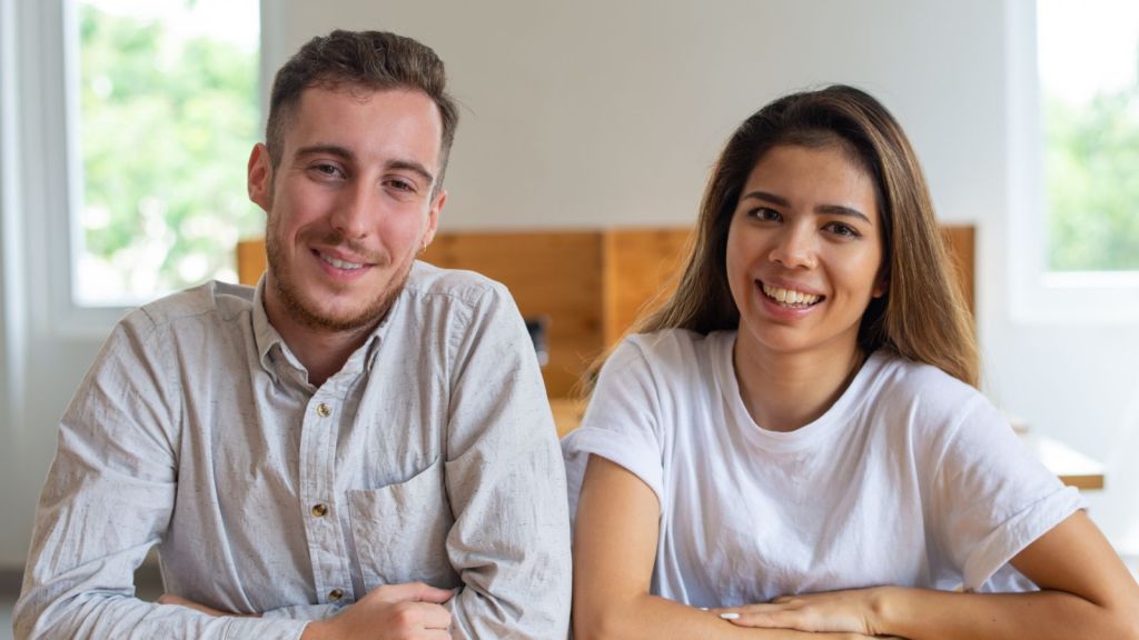 Man and woman sitting beside each other and smiling