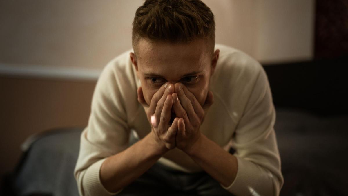 anxious man sitting in dim room