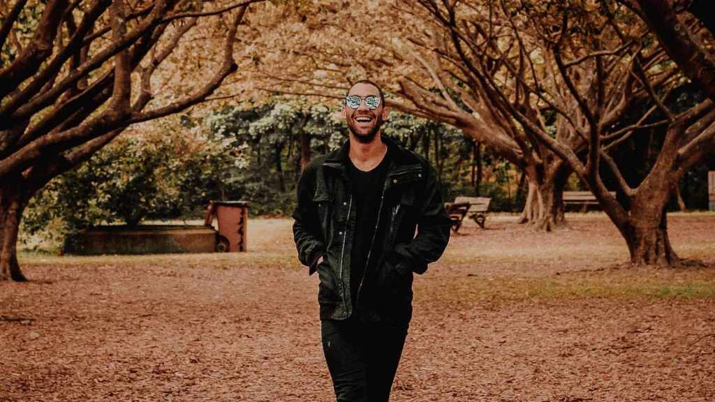 happy man walking in the park on a fall day
