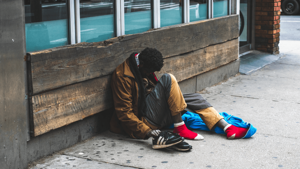 Daycare Parent Became Concerned After Finding Someone Camping In The Parking Lot, So They Contacted Authorities And Had The Person Removed homeless man hunched over