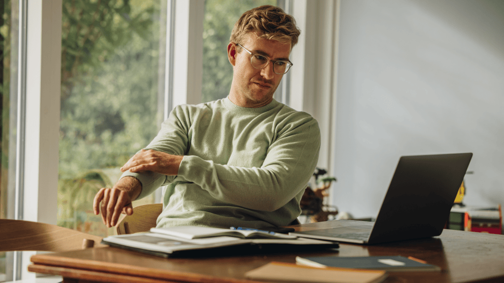 man in t shirt working on his laptop