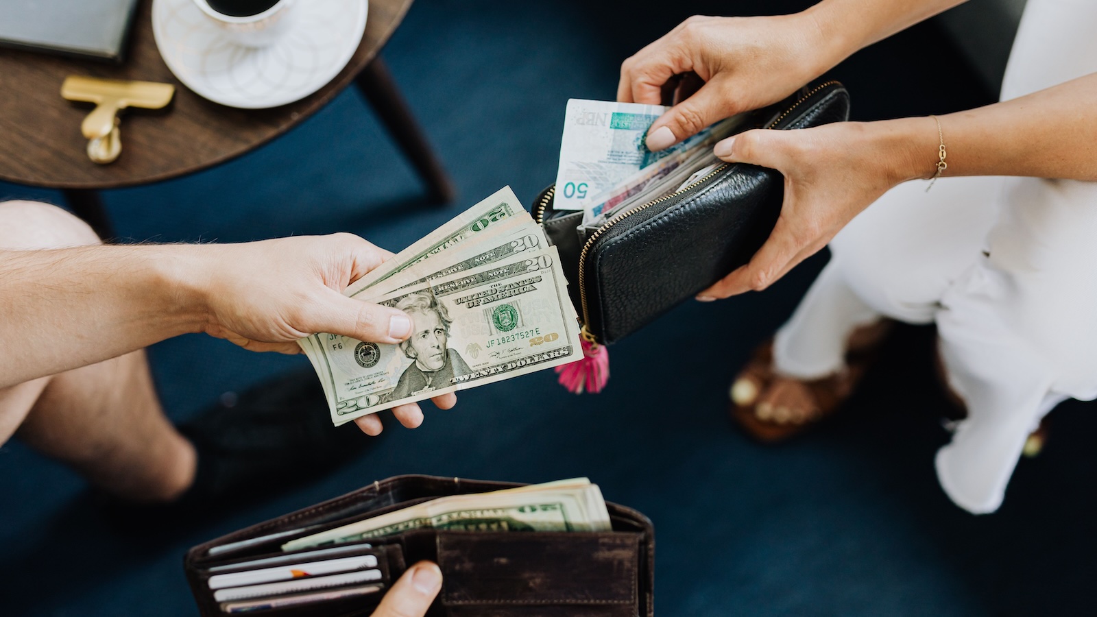 person handing over money from a wallet