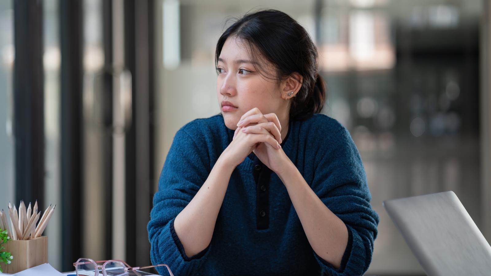 A Womans Manager Wants To Set Her Up On A Date With Her Brother And Shes Not Sure How To Say Shes Not Interested young woman looking out a window