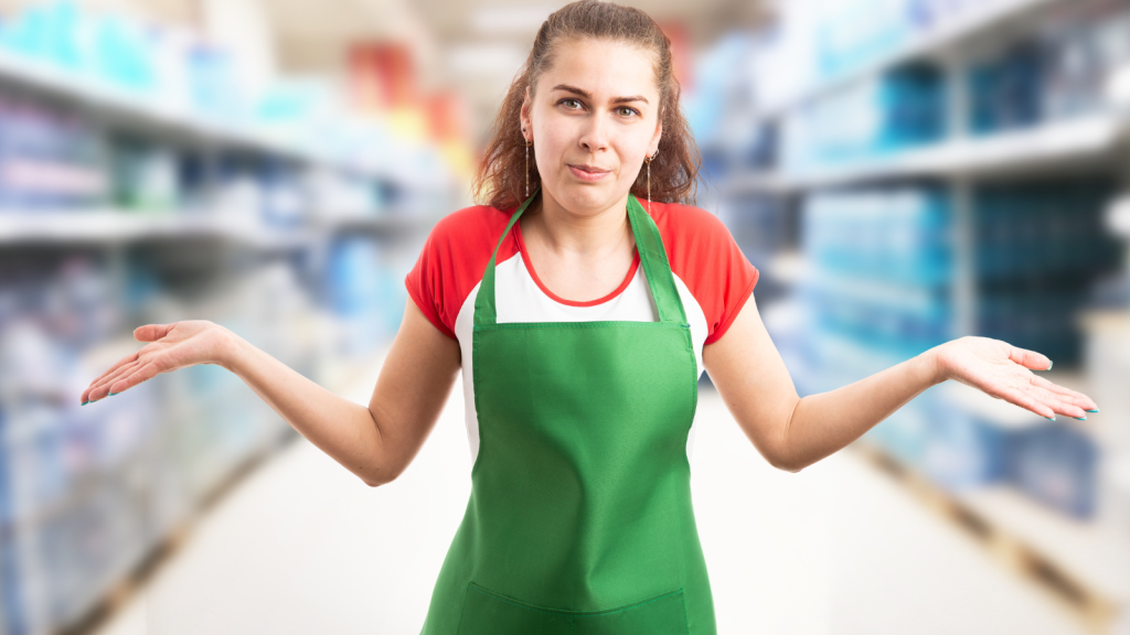 woman in apron in store with a surprised look on her face