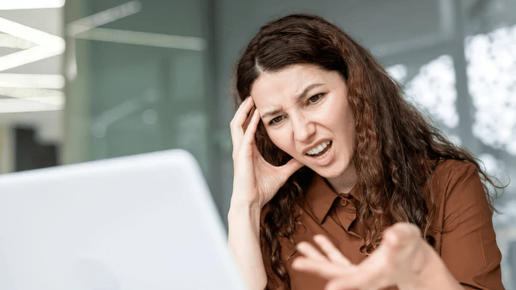 woman looking annoyed at her computer