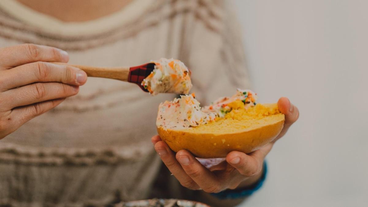 woman spreading cream cheese on a bagel