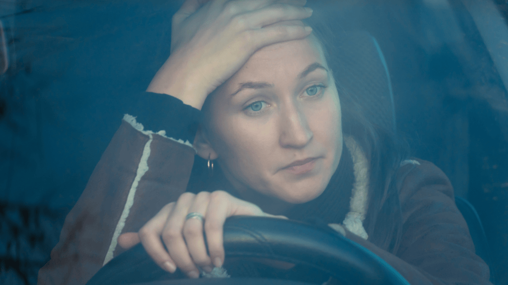 young woman driving while frustrated