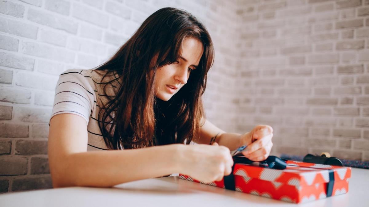 Womans Parents Made Her Holidays Disappear For Years To Favor Her Brother, And Now Theyve Turned On Her For Finally Crying Over A Gift From Her Boyfriend young woman opening a gift